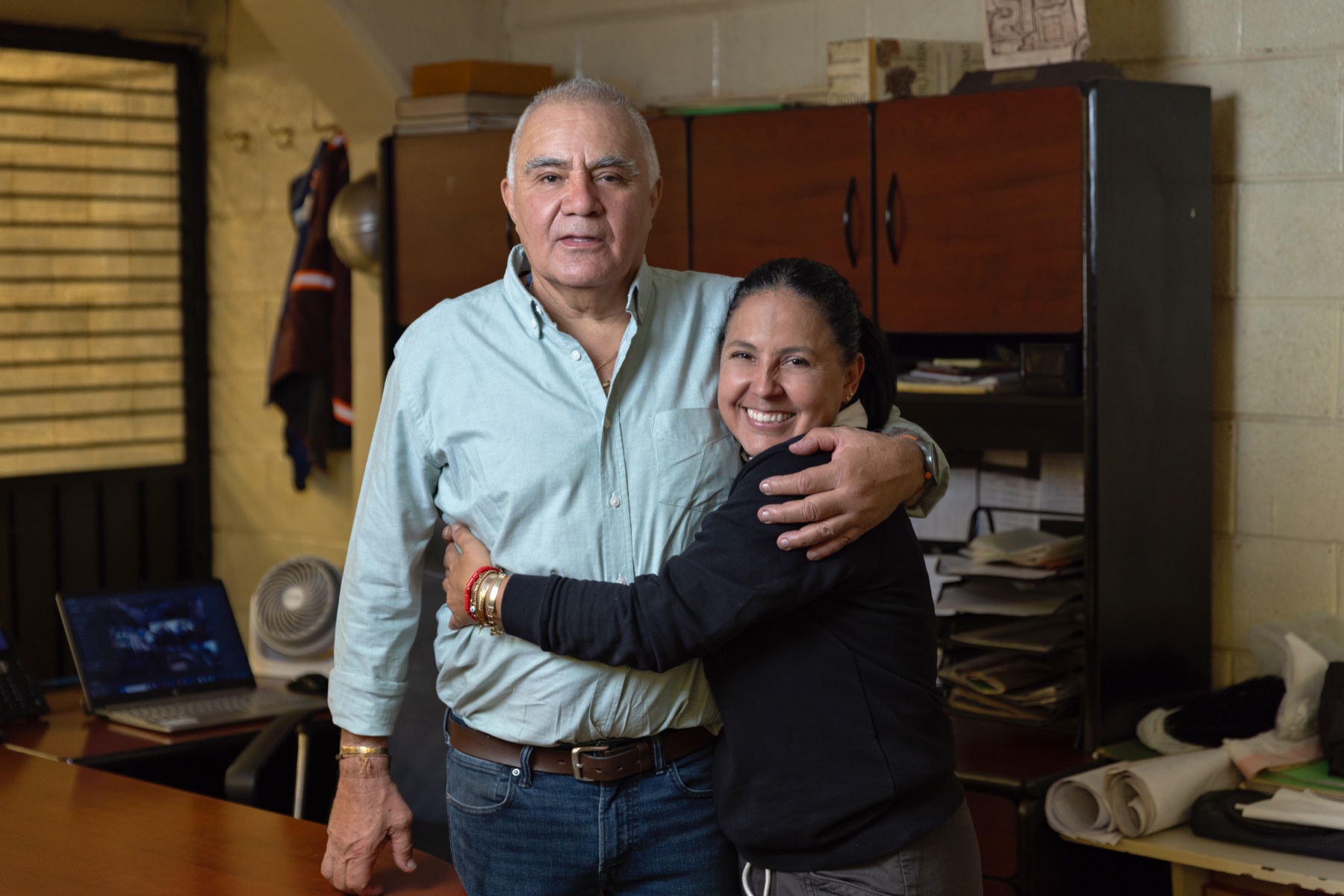 El directivo abrazado con una colaboradora; tono cálido, empresa familiar.